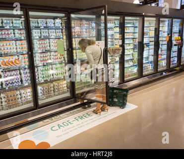 Un acquirente sceglie cafe-libera le uova in un raffreddatore nella nuova Whole Foods Market in Newark, NJ sul giorno di apertura Mercoledì, 1 marzo 2017. Il negozio è la catena al XVII store per aprire in New Jersey. Il 29,000 piedi quadrati di store situato nel ristrutturato ex Hahne & Co. di department store edificio è visto come un presagio della rivitalizzazione di Newark che mai pienamente recuperato dai tumulti negli anni sessanta. (© Richard B. Levine) Foto Stock