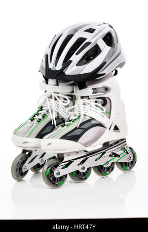Una coppia di pattini a rotelle con casco su sfondo bianco Foto Stock