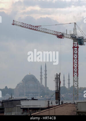 Vista di gru a torre usata in costruzione con vista distante la moschea di Istanbul TURCHIA Foto Stock