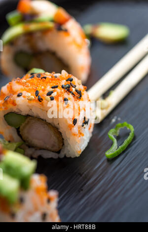 Sushi fresco rotoli servita su pietra scura piastra. Set di Sushi con aragosta, Avocado, caviale e sesamo nero. Cucina tradizionale giapponese. Foto Stock
