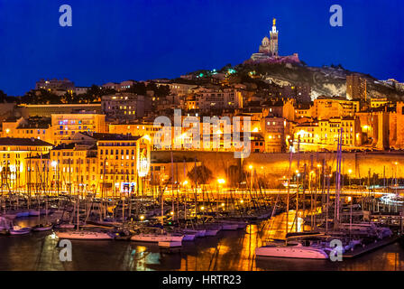 Il porto di Marsiglia a notte. Guardando verso la Cattedrale de Notre-Dame-de-la-Garde alta su una collina che si affaccia sulla città. Cote d Azur in Sout Foto Stock