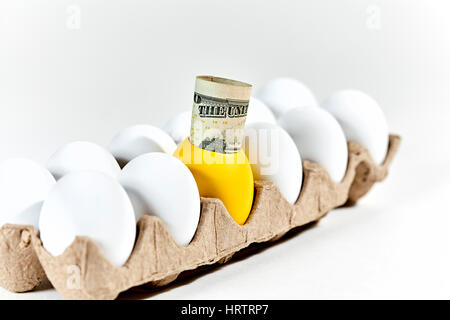 Le uova bianche in scatola di cartone con un Golden Egg e la moneta americana uscente del Golden Egg con profondità di campo Foto Stock