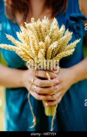 Bouquet con spikelets di grano vicino fino a madre le mani Foto Stock
