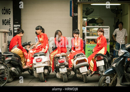 Hanoi, Vietnam - Aprile 25, 2014: Ragazze in tradizionale Ao dai vestiti sono in attesa per la cerimonia di nozze sulla strada di Hanoi. Foto Stock