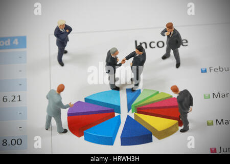 Vista dall'alto il fuoco selettivo di imprenditore in miniatura di handshake cerchio su sfondo grafico come impegno e il concetto di investimento. Foto Stock