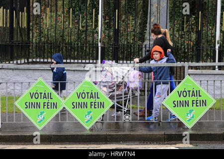 Belfast, Irlanda del Nord. 4 Marzo, 2017. Una famiglia a piedi passato vecchi manifesti elettorali nella parte occidentale di Belfast, Sabato, 4 marzo 2017 il giorno dopo il Northern Ireland Assembly elezioni. Il democratico partito unionista è stata strettamente restituito come il più grande partito ma Sinn Féin è stato il grande vincitore nel gruppo NI elezione. Il partito è venuto entro una sede del livello di disegno con la DUP, entrato in elezioni con 10 più sedi. Solo 1,168 Primi voti di preferenza separate le due parti e che per la prima volta gli unionisti non avrà una maggioranza generale a Stormont. Credito: Irish Occhio/ Foto Stock