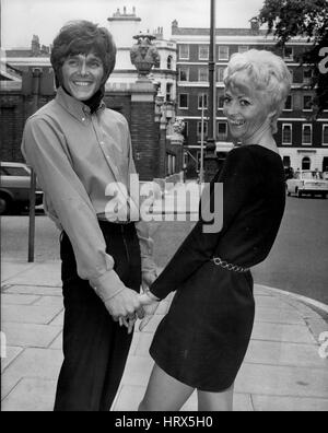 Giugno 06, 1969 - Billy Fury e la moglie di un paio di settimane frequentare la reception per lanciare il suo nuovo disco: cantante pop Billy Fury era accompagnato da sua moglie, ex modello Modello di moda Judith Hall, quando ha sposato recentemente quando ha partecipato ad un ricevimento a E.M.I. uffici per lanciare il suo nuovo disco '' invito per la Mia Rose'', che sarà rilasciato il prossimo 4 luglio. Il giovane è appena tornato da un viaggio di nozze Majerca. Mostra fotografica di mano nella mano Billy Fury e sua moglie Judith sono illustrati a oggi la reception. (Credito Immagine: © Keystone Press Agency/Keystone USA via ZUMAPRESS.com) Foto Stock