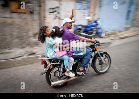 Venezuela, Caracas, Petare, Miranda membro 06/04/2012. Biker con due ragazze salita pendio in El Nazareno quartiere a Petare. Foto Stock