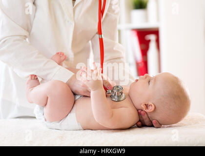 Pediatra esamina cinque mesi baby boy. Medico utilizzando uno stetoscopio per ascoltare il bambino petto controllare il battito cardiaco Foto Stock
