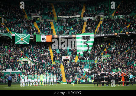 I giocatori di entrambe le squadre tenere un minuto di silenzio in memoria di Tommy Gemmell durante la Ladbrokes Premiership scozzese corrispondono al Celtic Park di Glasgow. Foto Stock