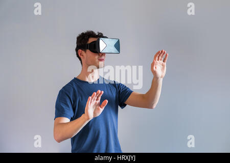 Persona che indossa una realtà virtuale (VR) auricolare o testa-display montato (HMD) bicchieri Foto Stock