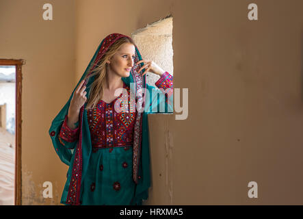 Una donna in tradizionali Omani vestito in un villaggio abondoned in un deserto Foto Stock