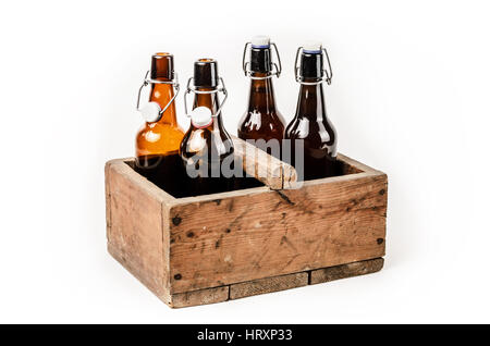 Le bottiglie di birra in una vecchia scatola di legno su sfondo bianco Foto Stock