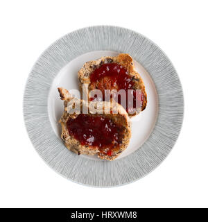 Piastra con due hot teacakes tostato con marmellata su sfondo bianco Foto Stock