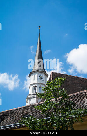 VIENNA, Austria - 29 luglio 2016: torre di una chiesa presso il centro storico di Vienna sopra i tetti e un albero su una soleggiata giornata estiva. Foto Stock