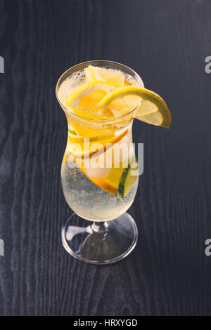 Fresca bevanda alcolica con agrumi scuro su sfondo di legno Foto Stock