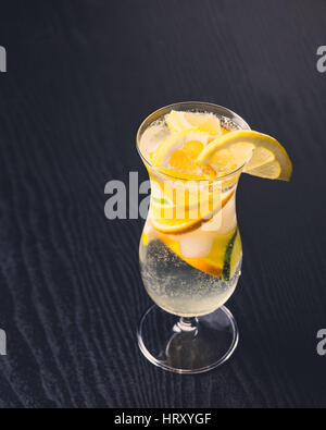 Fresca bevanda alcolica con agrumi scuro su sfondo di legno Foto Stock