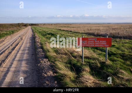 Segnale di avvertimento accanto a via attraverso M.O.D poligoni di tiro, Salisbury Plain, Wiltshire, Regno Unito, aprile 2015. Foto Stock