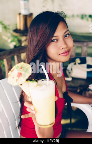 Attraente giovane ragazza asiatica in estate bere succo pineaple Foto Stock