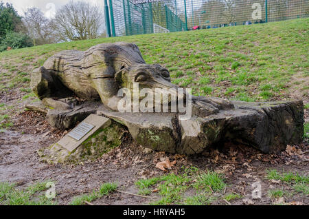 Una scultura in legno di un sonno cane in Prospect Park in lettura si erge come un memoriale di un defunto collega. Foto Stock