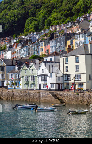 Un postino recapita le lettere per le case colorate di rivestimento del Riverside a e al di sopra di Bayards Cove in Dartmouth, Devon, Inghilterra, Regno Unito Foto Stock