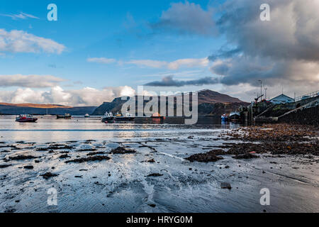 Ben Tianavaig e suono di Raasay sul Loch Portree, sull'Isola di Skye in Scozia, contro un cielo drammatico, guardare dal porto al molo e barche Foto Stock