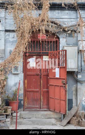 Vecchio rosso porta in legno tradizionale di un hutong edificio residenziale, Pechino Foto Stock