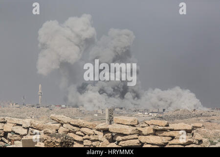 Mosul, Ninive, Iraq. 1 Mar, 2017. Una grande esplosione di una coalizione airstrike edifici sprofonda nel wadi Hajjar quartiere di Mosul occidentale con una nube di polvere e fumo, Marzo 1, 2017. Forze di Terra si basano su precise le incursioni aeree come questo a loro sostegno contro le minacce come ISIS suicidio auto bombe. Credito: Nish Nalbandian/ZUMA filo/Alamy Live News Foto Stock