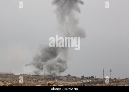 Mosul, Ninive, Iraq. 1 Mar, 2017. Il cloud risultanti da una coalizione airstrike su una posizione di ISIS nani edifici nel Wadi Hajjar quartiere di Western di Mosul, Marzo 1, 2017. Irachena forze speciali unità furono perseguitati da mitragliatrice fuoco dal minareto della moschea nella foto fino a quando questo airstrike. Credito: Nish Nalbandian/ZUMA filo/Alamy Live News Foto Stock