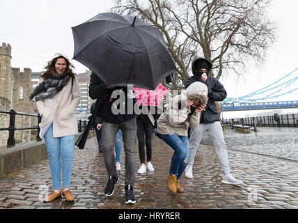 Londra, Regno Unito. Mar 5, 2017. I turisti sono catturati in una pesante pioggia vicino alla Torre di Londra. Credito: Vickie Flores/Alamy Live News Foto Stock