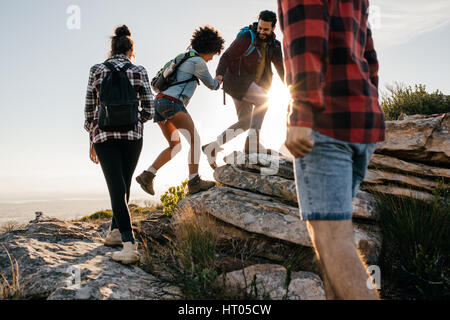 Gruppo di escursionisti con zaini a camminare su una montagna. Quattro amici fare un escursione in natura. Foto Stock