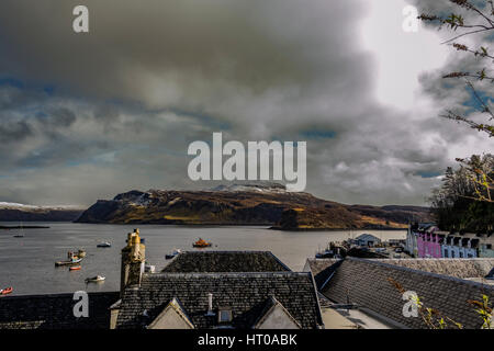 Ben Tianavaig e suono di Raasay attraverso Portree Harbour, sull'Isola di Skye in Scozia, contro un cielo drammatico Foto Stock