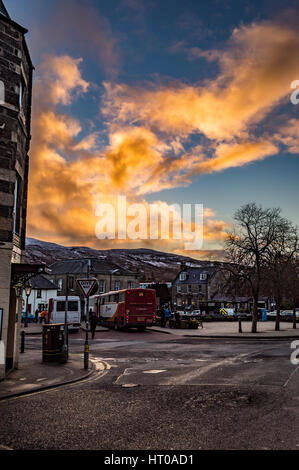 Somerled Square, Portree, Isola di Skye, contro golden incandescente nuvole su un inverno di pomeriggio Foto Stock