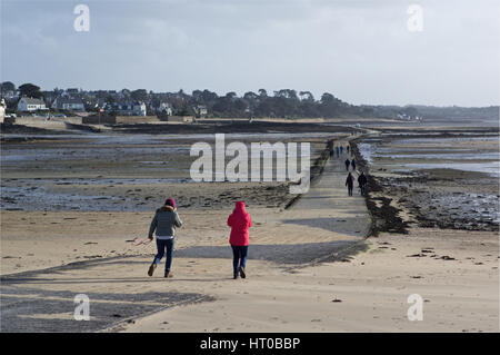 Folk attraversando a piedi il causeway esposta a Carantec, Finisterre, Brittany Foto Stock