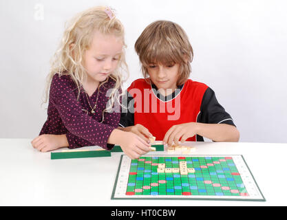 Geschwister spielen miteinander Scrabble - sorella e fratello giocare insieme Foto Stock
