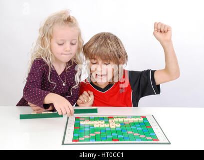 Geschwister spielen miteinander Scrabble - sorella e fratello giocare insieme Foto Stock