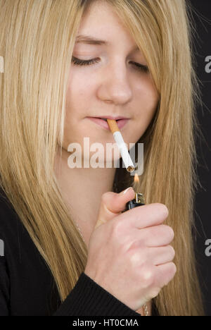 Jugendliches M‰dchen z'ndet sich eine Zigarette un - Teenager fuma una cigaret Foto Stock