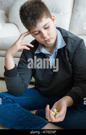 Adolescente tenendo una manciata di pillole e pensare al suicidio Foto Stock