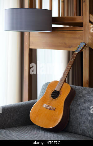 Accogliente soggiorno con la chitarra sul divano Foto Stock