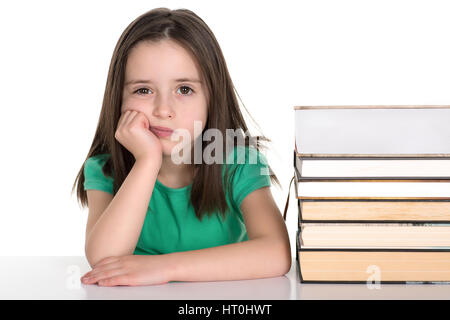Scuola ragazza seduta dalla pila di libri con grim annoiato faccia. Isolato su uno sfondo bianco. Foto Stock
