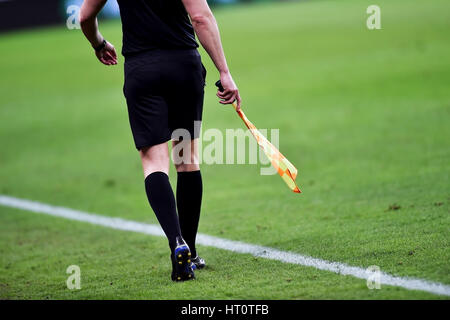 Arbitro assistente in movimento lungo il diversivo durante una partita di calcio Foto Stock