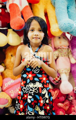 Bella giovane bambina in piedi in un orso di peluche shop Foto Stock