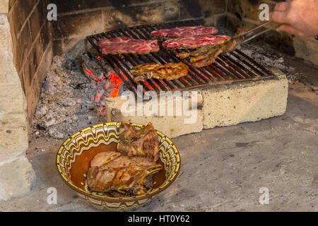 La tostatura carni fresche nel camino e ciotola con bistecca . Fare barbecue Foto Stock