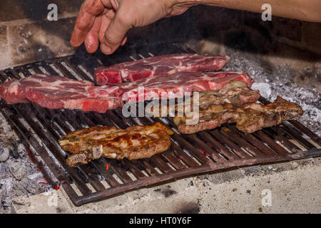 La tostatura carni fresche nel camino . Fare barbecue Foto Stock