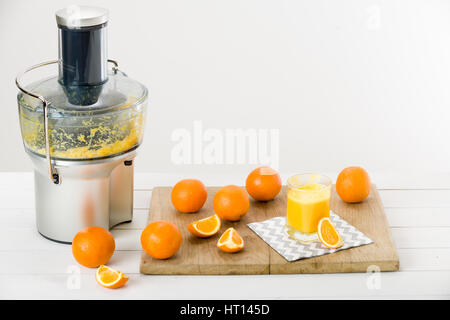 Moderno spremiagrumi elettrico e preparata di fresco e succo di arancia, sfondo bianco Foto Stock