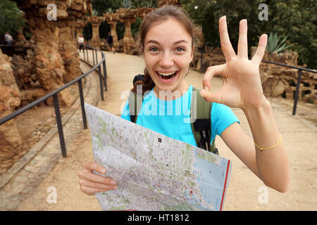 Escursionismo. Entusiastico tourist mostra bene gesto. Giovane ragazza felice utilizzando mappa di viaggio durante la sua escursione. Viaggiare in Spagna. Foto Stock