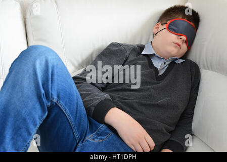 Teen dorme durante il giorno nella maschera per dormire Foto Stock