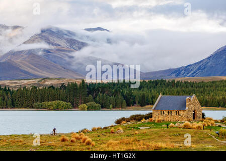 La Chiesa del Buon Pastore sulle sponde del Lago Tekapo e le colline circostanti sotto le nuvole Foto Stock