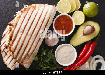 Quesadilla con carne macinata, fagioli, avocado e formaggio vicino sul tavolo. vista orizzontale dal di sopra Foto Stock