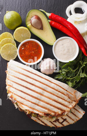 Cibo messicano: Quesadillas con carne di manzo, fagioli, avocado e formaggio vicino sul tavolo. vista verticale da sopra Foto Stock